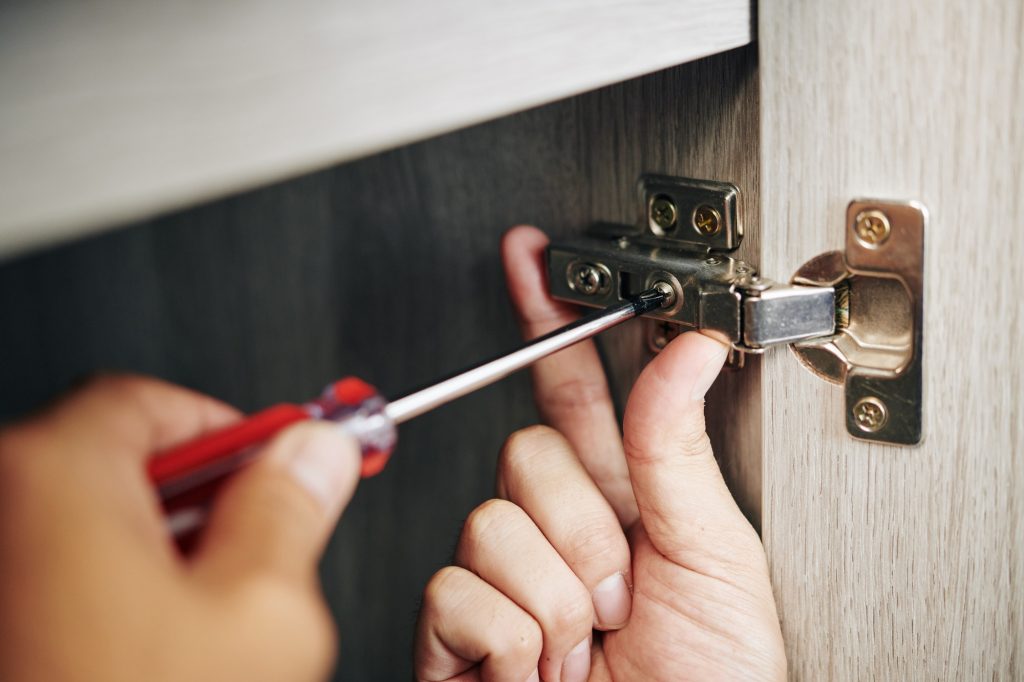 Man install and adjust cabinet door hinge
